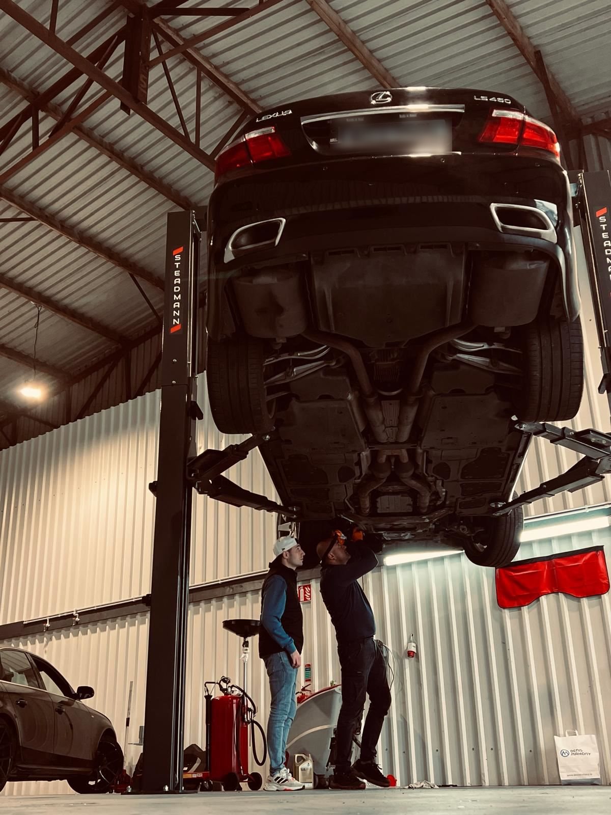 Mechanics carrying out an underbody inspection at Car Avenue workshop in Ashbourne